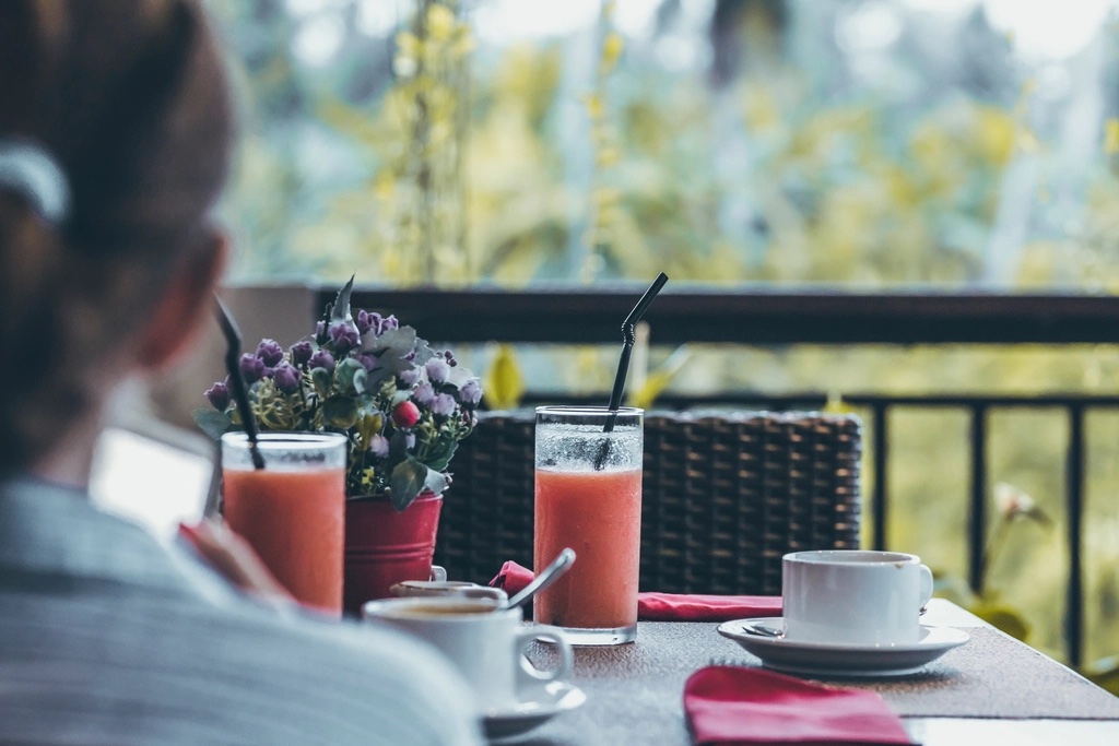 Una mujer desayuna en el balcón